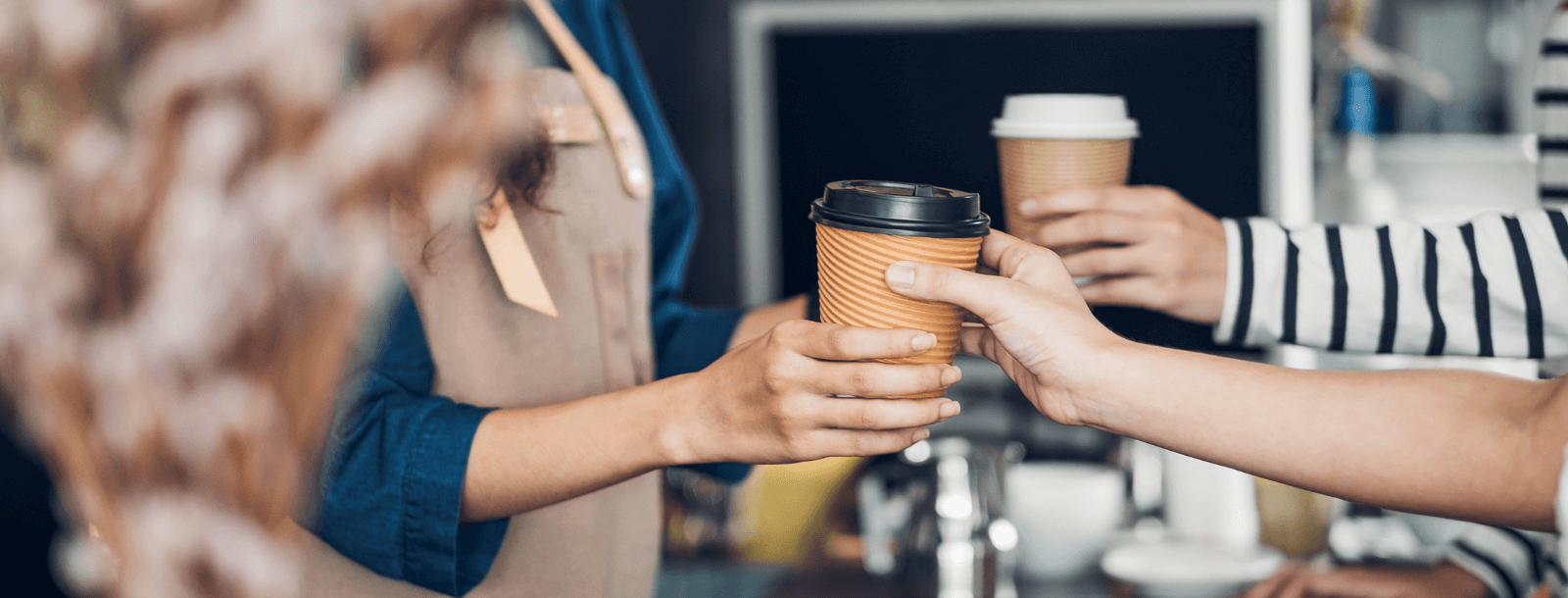 People getting handed coffee at a coffee shop