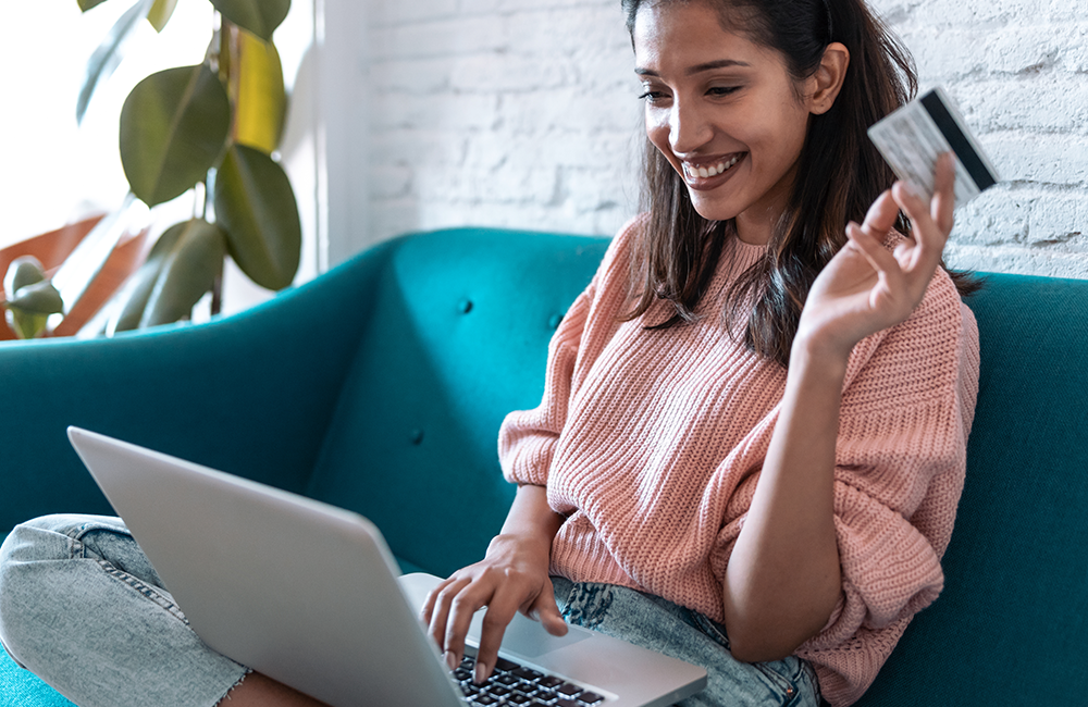 woman on sofa holding debit card