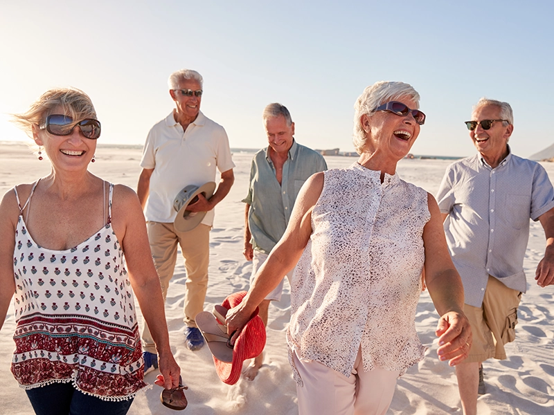 retired people laughing on a beach